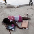 Enero de 2010. Una joven de 15 a&ntilde;os yace muerta tras haber sido disparada en la cabeza durante un saqueo a una tienda en Puerto Pr&iacute;ncipe (Hait&iacute;).