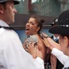 Una de las feministas se debate entre las manos de la policía