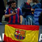 Un aficionado del Barça, junto a una bandera de España con el escudo culé