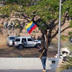 Un hombre ondea la bandera venezolana.&nbsp;