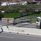 A sign reading 'Spanish bitch' is seen as a crane lifts remains of a road blockade set up by Catalan separatists on AP-7 motorway linking Spain to neighbouring France, near Figueras on March 27, 2018. Spanish riot police broke up a blockade by C...