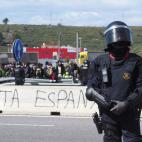 A Spanish riot policeman stands guard after police broke up a road blockade set up by Catalan separatists on AP-7 motorway linking Spain to neighbouring France, near Figueras on March 27, 2018. Spanish riot police broke up a blockade by Catalan ...