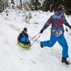 Dos jóvenes se divierten con su trineo en la nieve que ha caído en el Alto de Erro (Navarra).