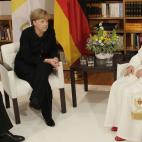 Benedict XVI speaks with German Chancellor Angela Merkel, center, and her husband Joachim Sauer, left, in the house of the German Bishops Conference in Berlin, Thursday, Sept. 22, 2011. Pope Benedict XVI is on a four-day official visit to his ho...