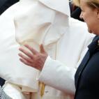 ALTERNATIVE CROP - German Chancellor Angela Merkel (R) looks on as Pope Benedict XVI has his robe blown in the face by the wind after arriving on September 22, 2011 at the Tegel airport in Berlin, where he starts his first state visit to his nat...