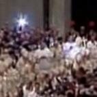 Grab taken from the Vatican TV shows a woman (R in red) jumping over a barrier towards Pope Benedict XVI (C carrying cross) during Christmas Eve at St Peter's Basilica on December 24, 2009. A woman threw herself at Pope Benedict XVI and dragged ...