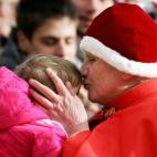 Vatican City, VATICAN CITY STATE: Pope Benedict XVI wearing a Camauro, a red velvet hat with white ermine trim used by popes in the 12th century, kisses a baby as he arrives on St Peter's square at the Vatican to preside over his weekly general...