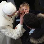 Rome, ITALY: Pope Benedict XVI kisses a child as he leaves Santa Maria Consolatrice church in Rome, 18 December 2005. The pontiff made his first pastoral visit, to a Rome parish. AFP PHOTO / PATRICK HERTZOG (Photo credit should read PATRICK H...