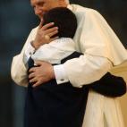 VATICAN CITY - OCTOBER 15: Pope Benedict XVI embraces a child at a meeting and prayer with children who made their First Communion during the year in St. Peter's Square October 15, 2005 in Vatican City. About 100,000 children and parents attend...