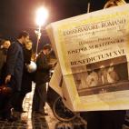 ROME - APRIL 19: A woman reads a newly printed edition of the newspaper L'Osservatore Romano at a newstand announcing the election of Pope Benedict XVI, Cardinal Joseph Ratzinger, April 19, 2005 in Rome, Italy. The 265th Pope will lead the worl...