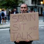 Un manifestante, con un cartel que reza "España, siéntate y hablar", proclama que pretende hacer TT Tsunami Democràtic