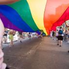 Más de 1 millón de personas han participado en la marcha del Orgullo Gay celebrada en Toronto. En la imagen, una mujer corre bajo una bandera gigante de arcoíris, durante las celebraciones por el Orgullo Gay en Canadá.