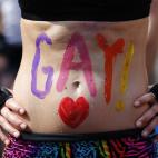 Una mujer enseña su vientre, con la palabra 'Gay' escrita en él, en Toronto (Canadá).