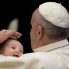 Pope Francis caresses a baby after his weekly general audience in the Paul VI hall at the Vatican, Wednesday, Jan. 7, 2015. (AP Photo/Alessandra Tarantino)