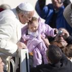 Pope Francis kisses a baby as he arrives for his weekly general audience, in St. Peter's Square, at the Vatican, Wednesday, Feb. 18, 2015. (AP Photo/Andrew Medichini)