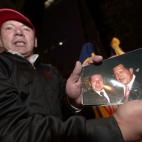 Un fan de Hugo Chávez muestra una foto en la que aparece con el presidente en la embajada venezolana en Quito, Ecuador.