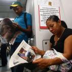 Pasajeros en el metro de Caracas leen la prensa local que abre con la muerte de Hugo Chávez.