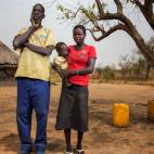Helen, 16, junto a su marido Jade, de 50, junto a su casa en Juba. Se casaron el año pasado. Ella afirma que hubiera preferido seguir en la escuela que casarse pero su familia no podía pagar su educación. 