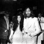 Beatle John Lennon and his wife, Yoko Ono, left, at an airport at an unknown location.