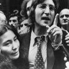 Former Beatle John Lennon and his wife Yoko Ono are shown talking to newsmen outside the U.S. Immigration offices in New York on Wednesday in March, 1972. At the hearing on his deportation, the defense submitted a petition containing 16,000 sign...