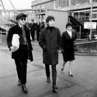 (L-R) John Lennon and George Harrison of The Beatles walk towards their plane at London Airport to return to Paris after a 24 hour visit home.