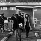 JOHN LENNON LEADS IN THE FOREGROUND AS "THE BEATLES" WALK OUT OF THE LONDON AIRPORT LEAVING THE QUEEN'S BUILDING (BACKGROUND) ON THEIR RETURN FROM FILM-MAKING IN THE BAHAMAS, 1965.