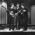 The Beatles (from left) Paul McCartney, John Lennon and George Harrison (1943 - 2001) performing at the London Palladium. (Photo by Les Lee/Getty Images)