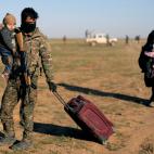 Un miembro de las milicias kurdas atiende a una mujer y a su beb&eacute;, reci&eacute;n escapados de Baghouz.&nbsp;
