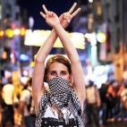 Una manifestante contra el Gobierno de Erdogan hace el símbolo de la victoria durante un enfrentamiento con la Policía en la plaza Taksim en Estambul el 22 de junio de 2013. La Policía turca usó cañones de agua para dispersar a los miles de...