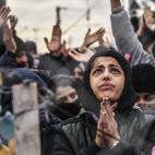 Los migrantes protestan tras una valla contra las restricciones que limitan el paso en la frontera grecomacedonia, cerca de Gevgelija, el 1 de diciembre de 2015. El 29 de noviembre, Macedonia terminó de construir una valla en la frontera con Gr...