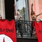 Activistas de Femen con el pecho al descubierto hacen el saludo nazi en un balcón con banderas donde se puede leer "Heil Le Pen" en una protesta contra el el Frente Nacional francés, partido de extrema derecha, y en honor a la figura de Juana ...