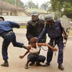 Un policía da una patada a una mujer durante una protesta con manifestantes del principal partido de la oposición, Unión por la Democracia y el Progreso Social (UDPS), el 30 de junio de 2006, en Kinshasa. Justo un mes más tarde se celebraron...