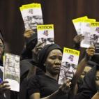 Miembros de asociaciones contra la violencia de género muestran panfletos contra esta persistente lacra durante la inauguración de la Cumbre de la Francofonía en Kinshasa el 13 de octubre de 2012.