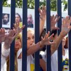 Lilian Tintori, la mujer del opositor venezolano encarcelado Leopoldo López, posa simbólicamente entre rejas el 14 de diciembre de 2015 en Caracas.