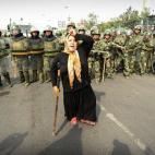 Policías antidisturbios chinos, tras una mujer musulmana de la etnia uigur durante una protesta en Urumqi el 7 de julio de 2009 después de varios días de tensiones.
