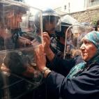 Una mujer, ante los policías antidisturbios durante una protesta organizada por la Agrupación por la Cultura y la Democracia en Argel el 3 de julio contra una ley que hacía del árabe la única lengua oficial del país, en una época de tensi...