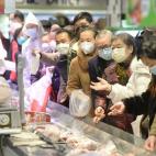Clientes chinos hacen sus compras protegidos por mascarillas