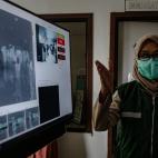 Un sanitario monitoriza la temperatura de los pasajeros de un vuelo en Indonesia