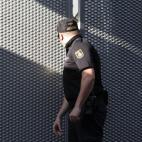 Un policía nacional cierra la puerta del garaje de la Audiencia Nacional tras la llegada de del extesorero del PP Luis Bárcenas hoy en un furgón de la Guardia Civil desde la prisión madrileña de Soto del Real.