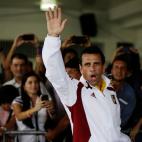 Opposition presidential candidate Henrique Capriles waves as he arrives to a polling station to vote in the presidential election in Caracas, Venezuela, Sunday, April 14, 2013. Capriles is running for president against Nicolas Maduro, the hand p...