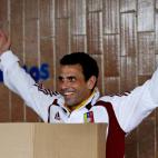 Opposition presidential candidate Henrique Capriles gestures from behind the voting booth as he votes in the presidential election in Caracas, Venezuela, Sunday, April 14, 2013. Capriles is running for president against Nicolas Maduro, the hand ...