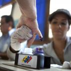 A voter has her finger marked with ink after casting her ballot in the presidential election in Caracas, Venezuela, early Sunday, April 14, 2013. Interim President Nicolas Maduro, who served as late President Hugo Chavez's foreign minister and v...