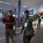 A voter gets directions from a soldier on where to cast his ballot in the presidential election at a polling station in Caracas, Venezuela, early Sunday, April 14, 2013. Interim President Nicolas Maduro, who served as the late Hugo Chavez's fore...