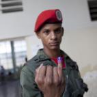 A presidential guard soldier shows his finger marked with ink after voting in the presidential election at a polling station in Caracas, Venezuela, Sunday, April 14, 2013. Interim President Nicolas Maduro, who served as the late Hugo Chavez's fo...