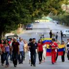 Venezuelans carrying their nation's flag walk to their consulate to vote in their country's presidential election in Havana, Cuba, Sunday, April 14, 2013. Interim President Nicolas Maduro, who served as late President Hugo Chavez's foreign minis...