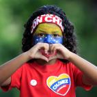 Venezuelan Mariangel Rosa, 5, flashes a heart symbol to journalists as she walks to the Venezuelan consulate with adults who will vote there during their country's presidential election in Havana, Cuba, Sunday, April 14, 2013. Interim President ...
