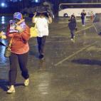 Voters brave the rain as they arrive by bus from Miami and throughout the southeastern United States to wait in line to vote at the New Orleans Venezuelan consulate's hosted national election at the Pontchartrain Center in Kenner, La., Sunday, A...