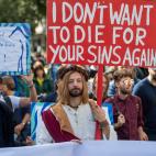 "No quiero volver a morir por vuestros pecados", dice la pancarta de este joven vestido de Jesucristo en Frankfurt.&nbsp;