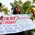 Una joven sostiene una pancarta mientras participa en una protesta contra la inacci&oacute;n gubernamental hacia el colapso clim&aacute;tico y la contaminaci&oacute;n ambiental en la India.&nbsp;
