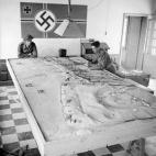 Soldados canadienses, estudiando los planos nazis sobre una maqueta de la playa.